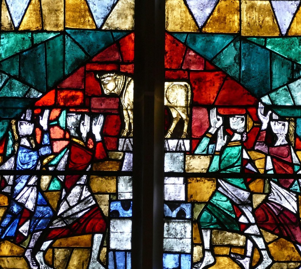 Stained glass church window of golden calf and worshippers
